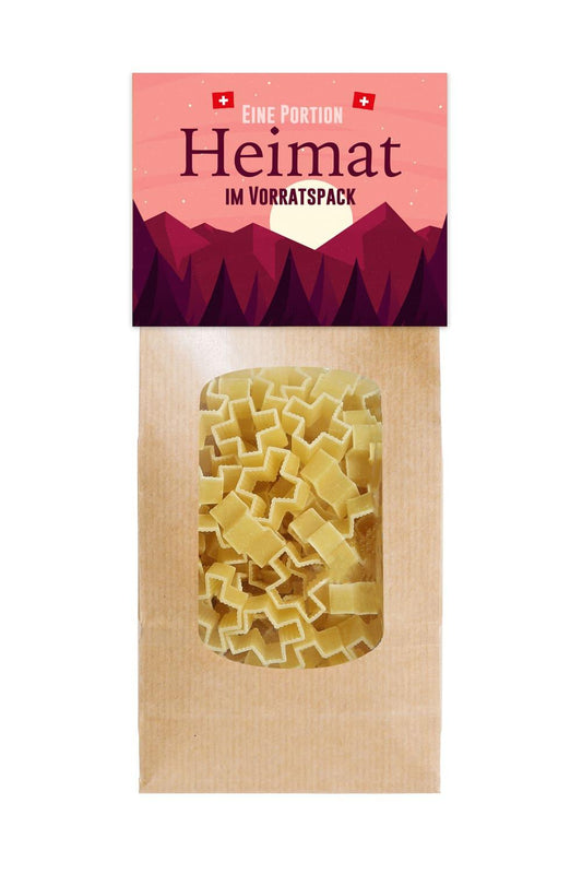 Die Pasta mit der Aufschrift: Eine Portion Heimat im Vorratspack. Die Pasta sind in Form eines Schweizerkreuzes. Schweizer Souvenir Geschenk.