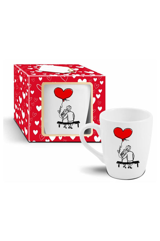 Dieses herzige Tasse ist ein perfektes Geschenk fuer Verliebte. Es zeigt wie sich zwei verliebte Menschen auf einer Sitzbank umarmen und in der Hand einen roten Herz Ballon halten. Ein perfektes Geschenk zum Valentinstag, zum Jahrestag oder einem sonstigen Anlass. In dieser Tasse steckt ganz viel Liebe! 