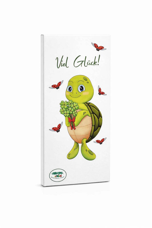 Schweizer Schokolade mit der Aufschrift: Viel Glueck. Die aufgedruckte Schildkroete haelt einen Strauss voller vierblaettrigen Kleeblaettern in der Hand. Diese Gluecksschokolade gibt es nur bei Geschenk Insel!