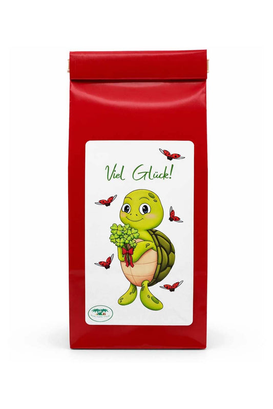 Tee mit der Aufschrift: Viel Glueck, und der niedlichen Schildkroete Lia. Die Schildkroete haelt einen Strauss voller vierblaettrigen Kleeblaettern in der Hand. 