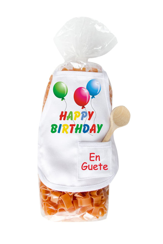 Die Happy Birthday Pasta sind in einer Herz-Form und in einer schoenen Verpackung. Auf der Mini Kochschuerze sind Ballone abgebildet und die Aufschrift: Happy Birthday. En Guete. Zusaetzlich befindet sich in der kleinen Tasche, ein kleiner Kochloeffel aus Holz. Einfach ein grossartiges und leckeres Geburtstagsgeschenk.